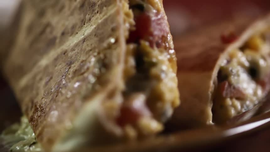 A pita sandwich is lifted from the plate