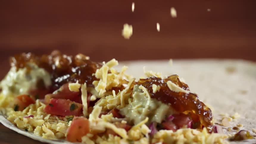 Garnish and toppings are dropped down on food on a plate