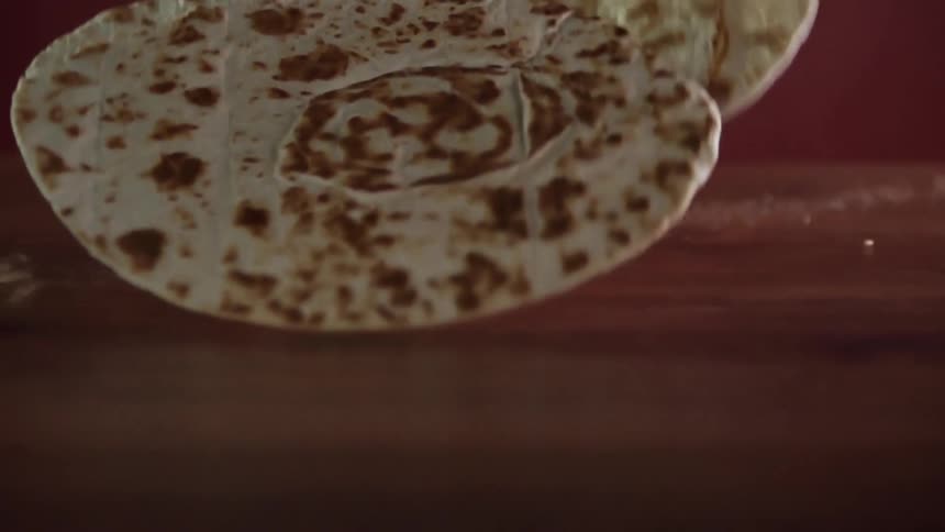 Two tortilla shells are dropped on the counter