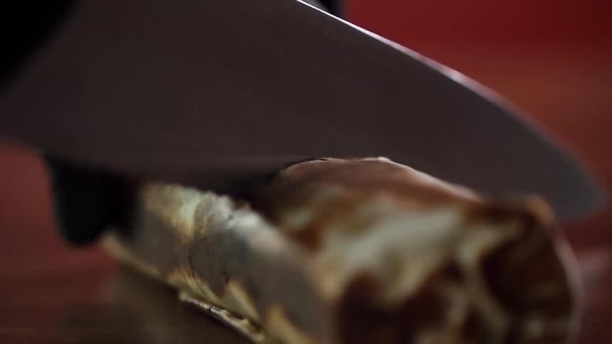 A person cuts in to food with a knife