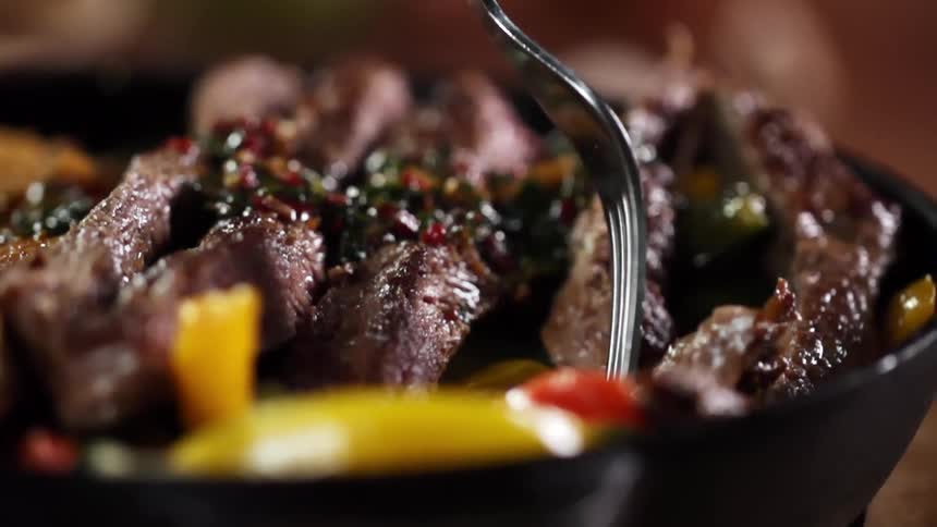 A fork picking up a piece of meat