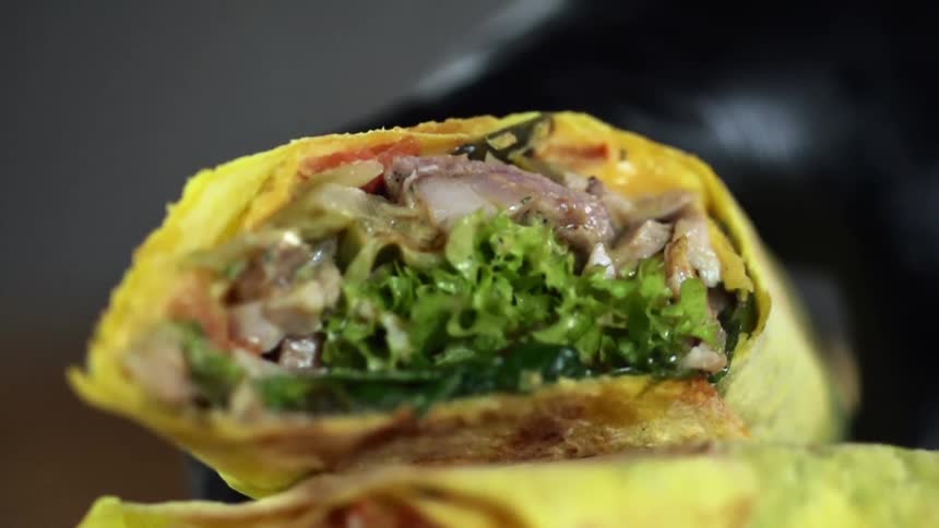 A person picks up a shawarma