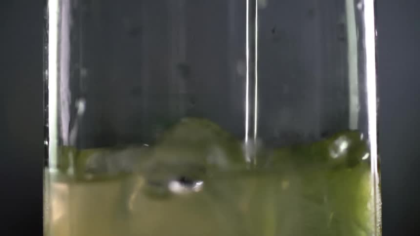 A white rum is poured into the glass full of ice