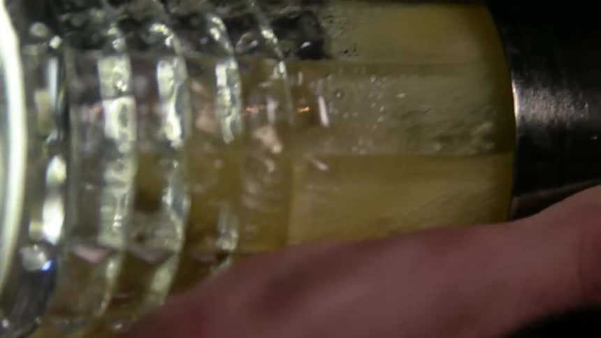 Hand shaking a cocktail inside a glass