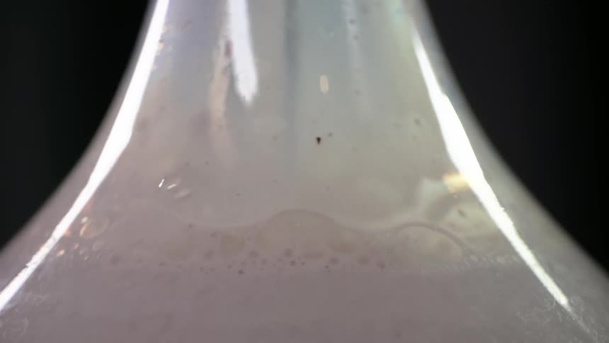 Milk forms bubbles inside a vase