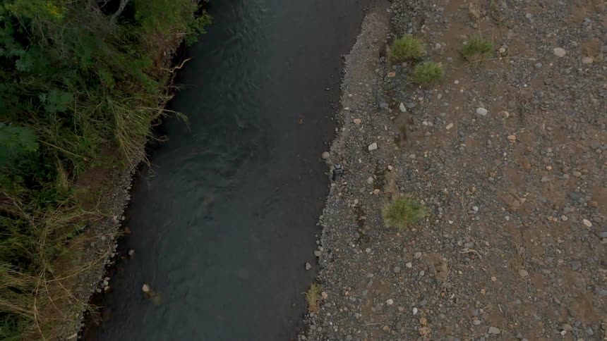 Aerial view of a man hiking along a stream