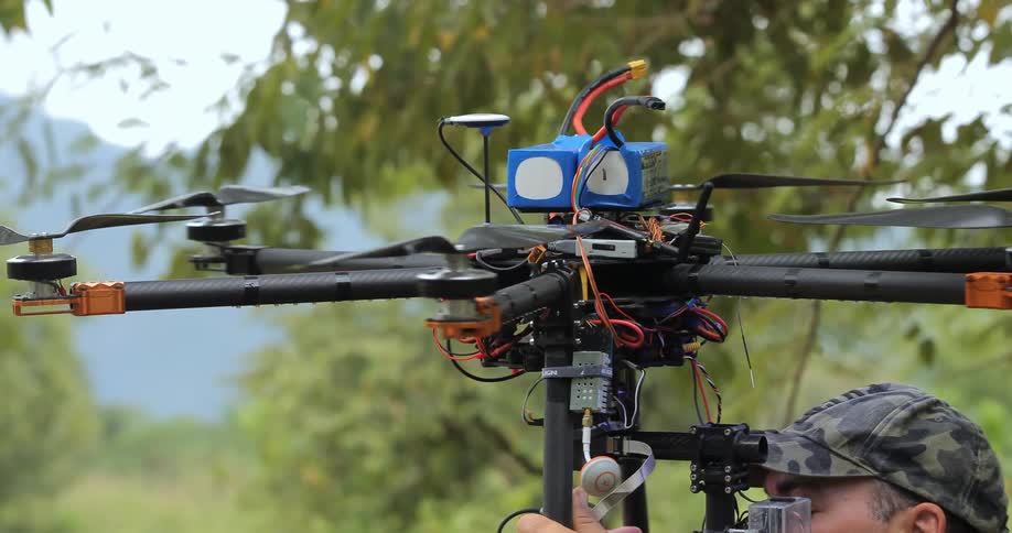 A man is holding a drone over his head