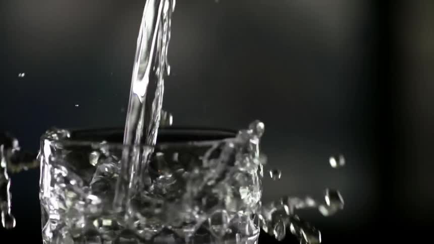 Close up of a jar pouring water into a glass