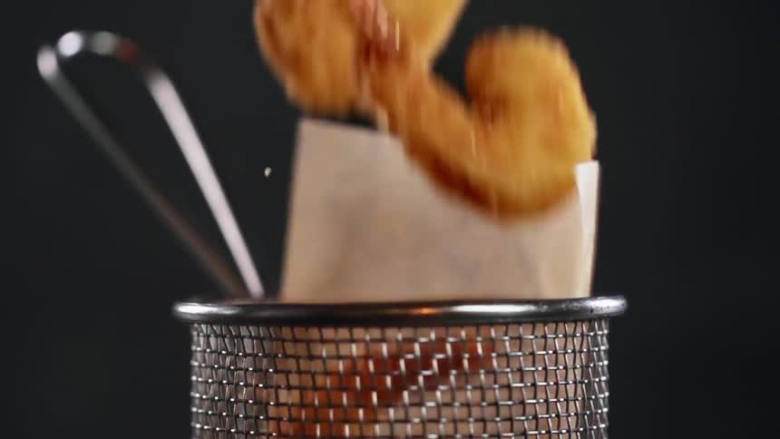 Fried shrimp covered in breadcrumbs is dumped into the bin