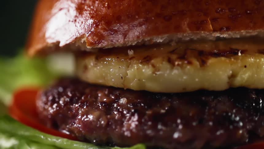 Close up of a gourmet hamburger with a slice of grilled pineapple