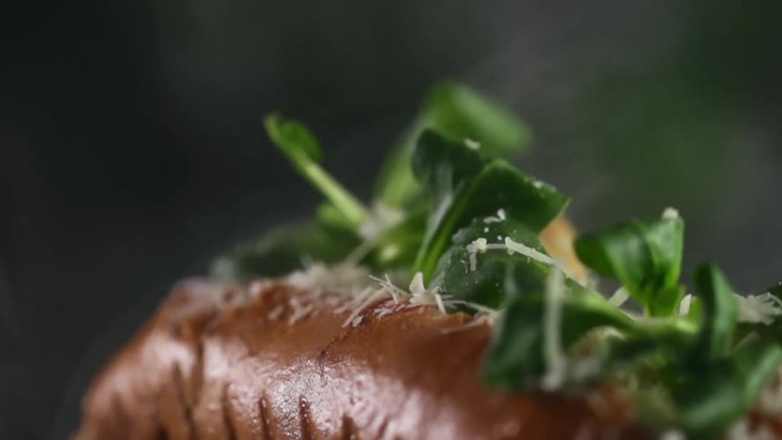 Hot dog sprinkled withg leafy greens and smoke coming out of it