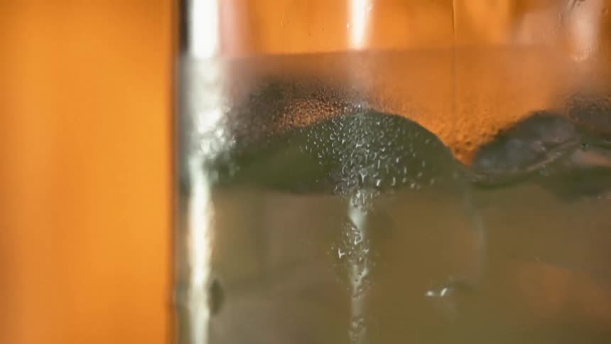 A beverage in a glass with ice