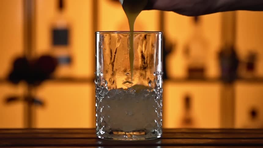 A person makes a drink in a bar