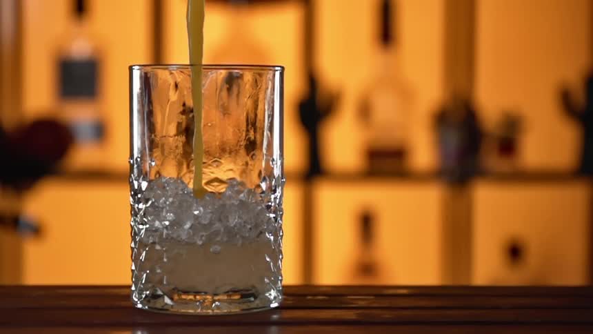 A drink being poured on a bar top