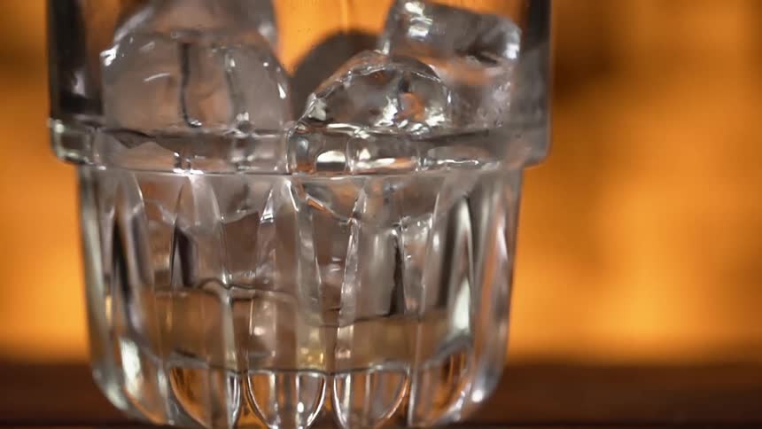 Water being poured in a glass with ice