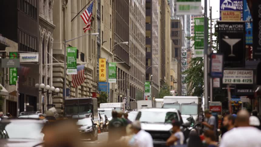 Pedestrians and cars in a busy street in new york city at day