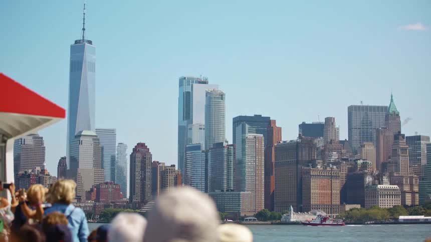 People on a boat take pictures of new york city skyline at day