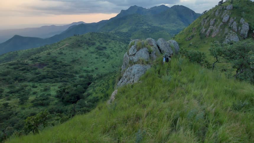 A hiker nears a large rock formation