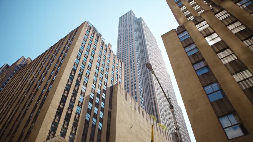 The tall building goes up into the clear sky