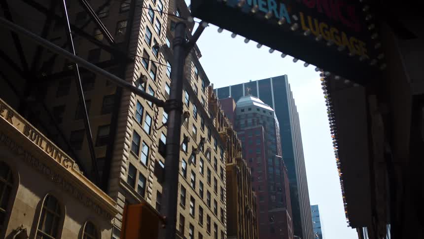 A city street with streetlights and signs with buildings and skyscrapers in the background