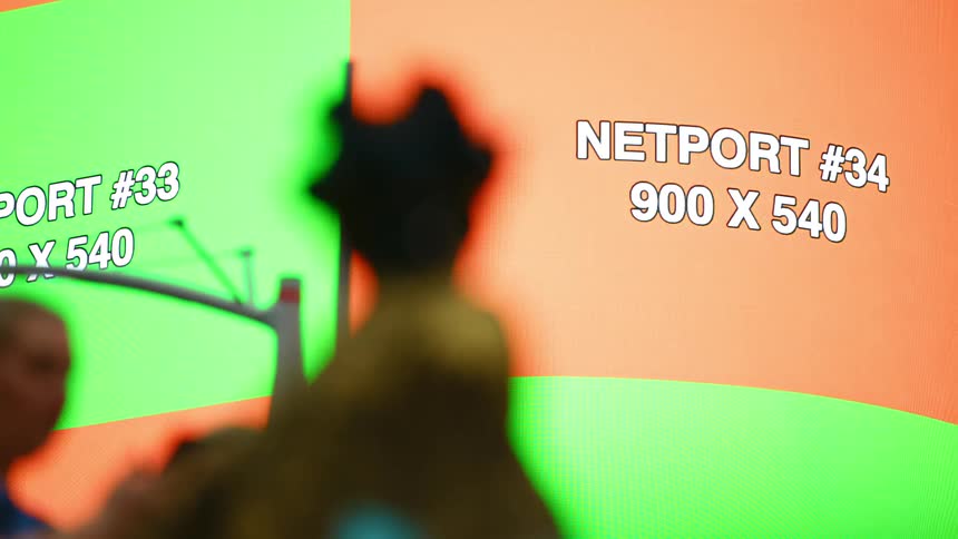 Woman standing with a large screen in the background