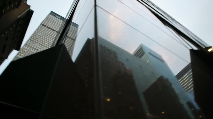 Tall skyscrapers reflecting in the glass facade of a building in the citys downtown