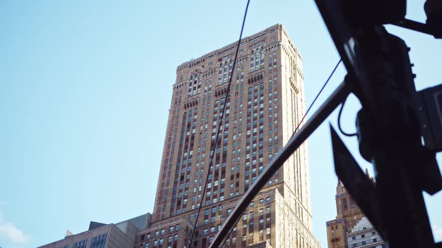A skyscraper towers over a city street sign in the daytime