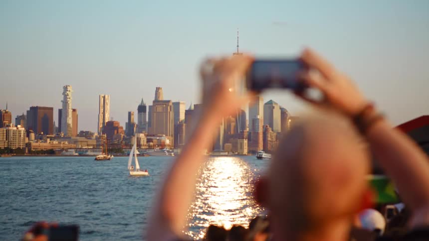Man takes picture of the one world trade center in new york city with his smartphone from a boat