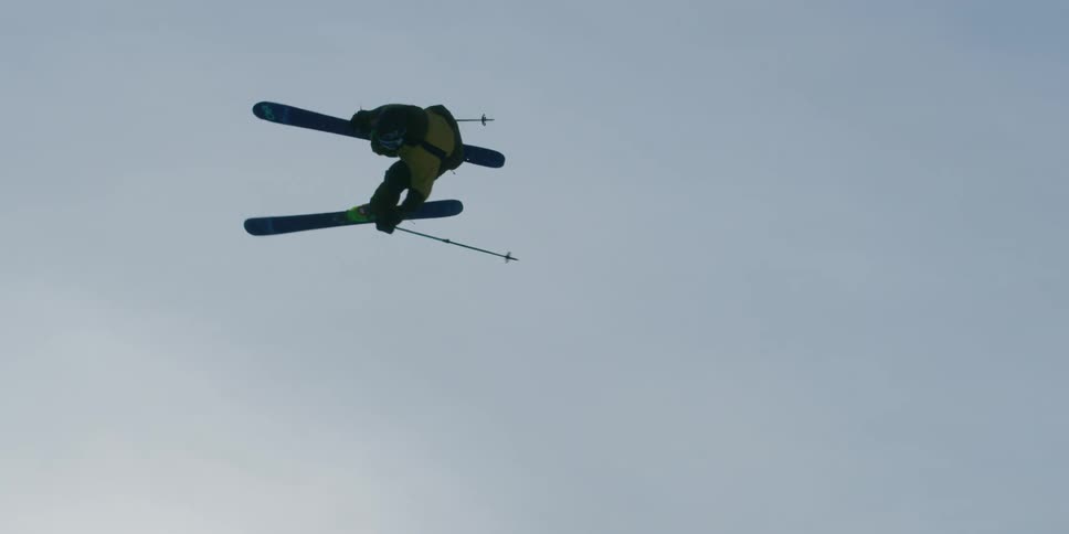 A skier flies and spins off a jump