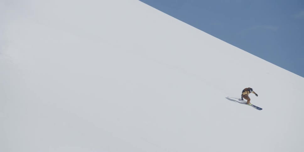 A skier makes turns down a mountain