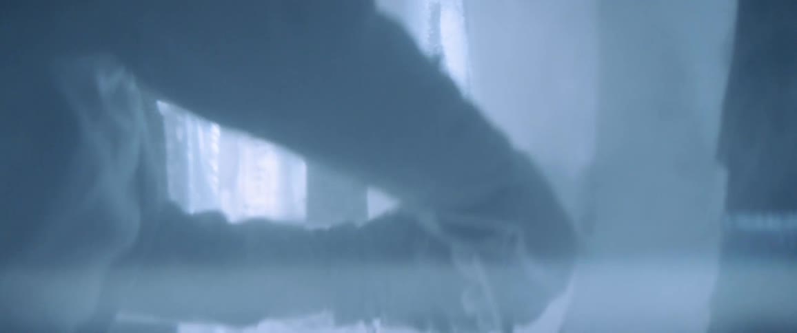 A man sculpts ice using a chainsaw