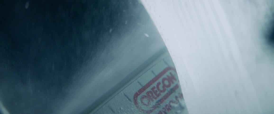 The chainsaw is cutting the ice in the dark