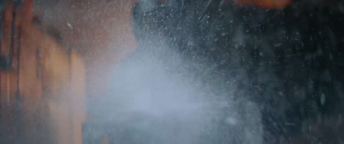 Man chips at a block of ice with a chainsaw