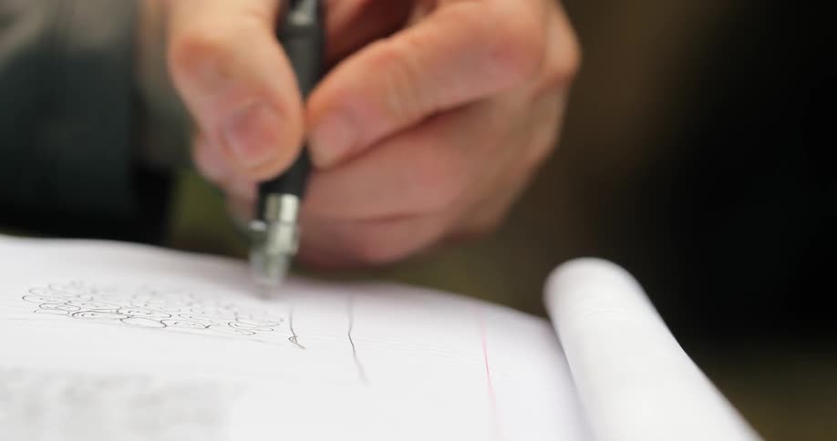 A person is writing with a pen in a notebook