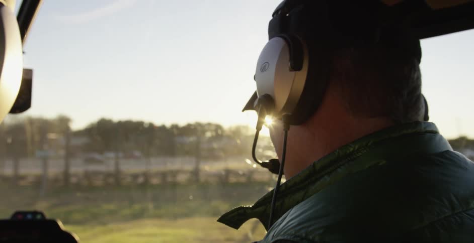 A man is talking as he sits in a cockpit
