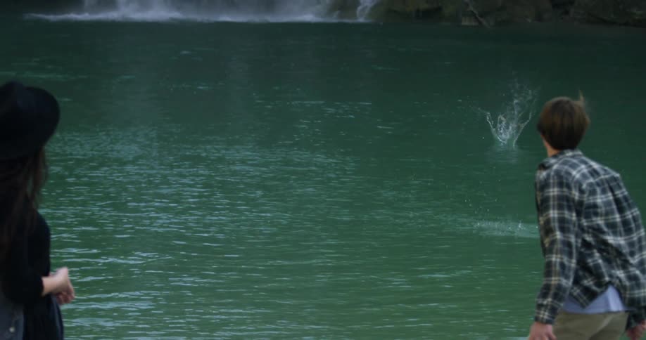 A man skips a rock across a body of water