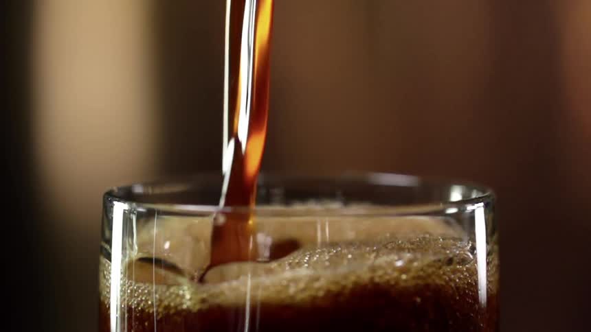 Liquid beverage pours into a glass