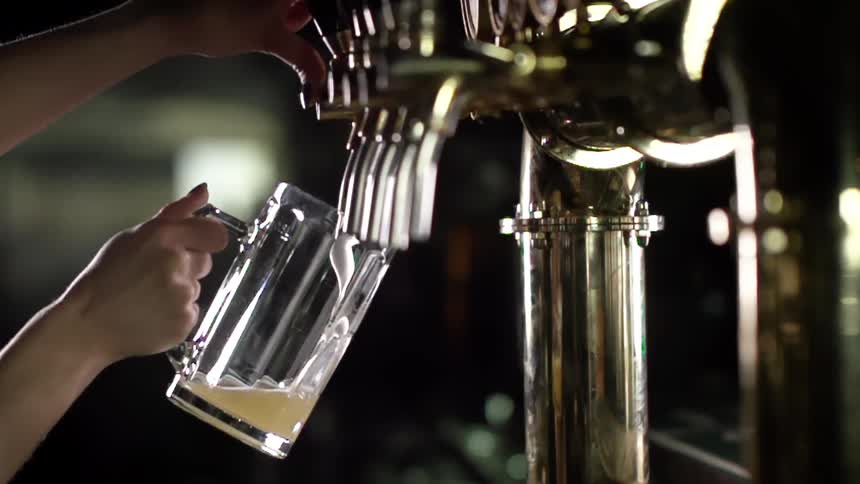 A beer mug is being filled by tap