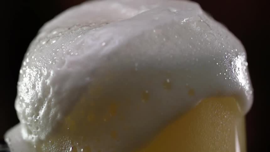 The beer is overflowing with suds