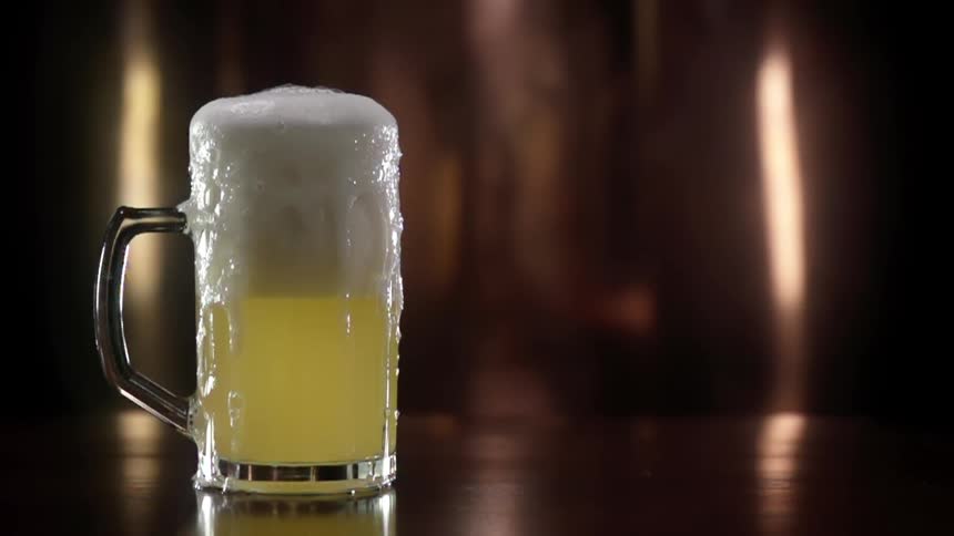 Beer foam overflows from the glass