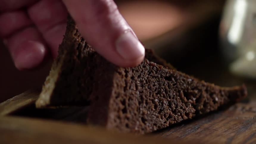 A man sets bread down on a wooden board