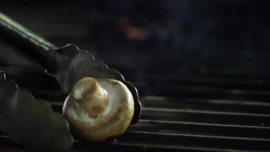 A mushroom being removed from a grill