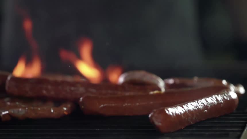 Sausages grilling over the smoking hot fire