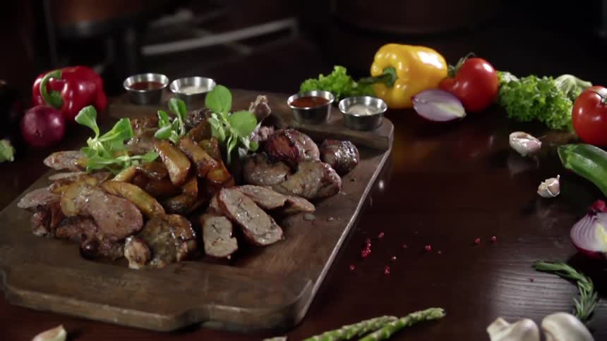 Garnish is dropped on the stack of steaks