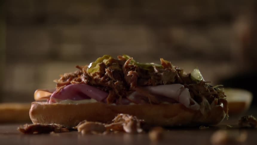 Pickles are dropped on to an open faced sandwich