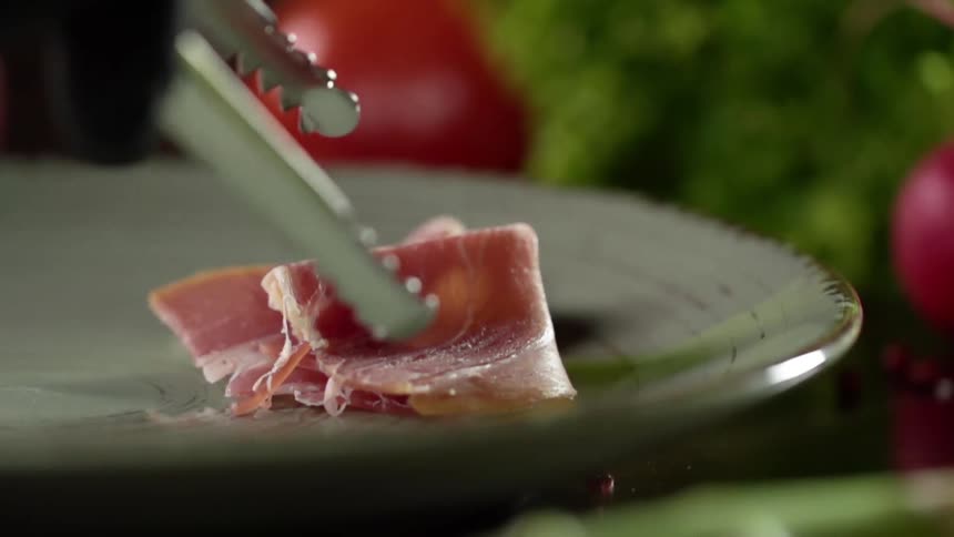 A person puts meat on a plate