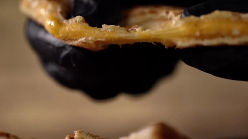 A person pulls apart a grilled cheese sandwich