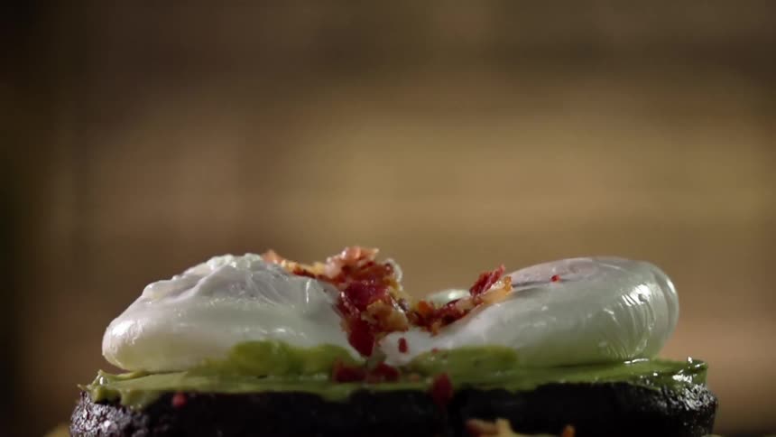 Bacon bits fall onto a burger