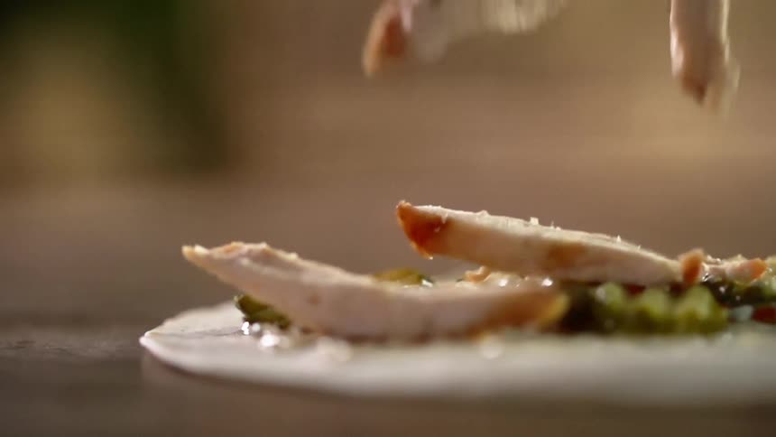 Cooked chicken falls onto a tortilla