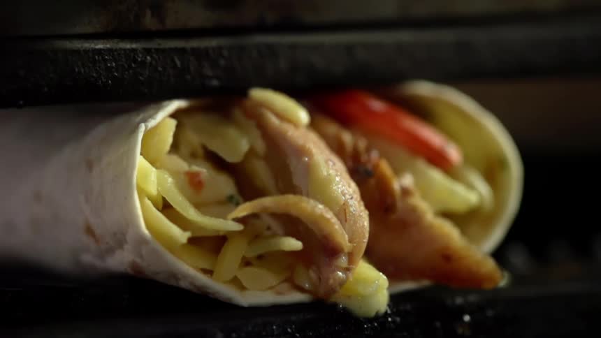 A burrito is being pressed in a machine